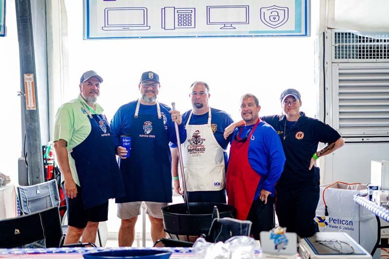A group of men wearing aprons are posing for a picture.