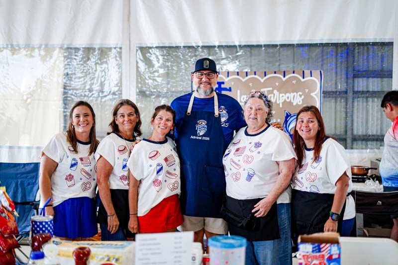 A group of people are posing for a picture in a tent.