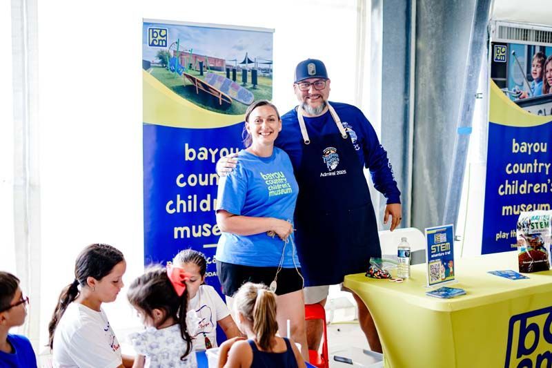 A group of people standing next to each other in front of a table.