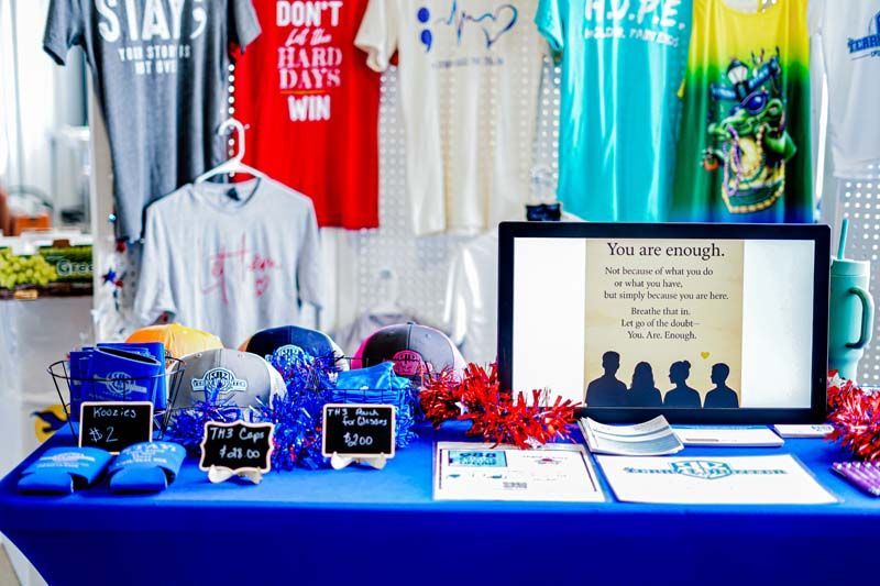 A table with t-shirts on it including one that says stays