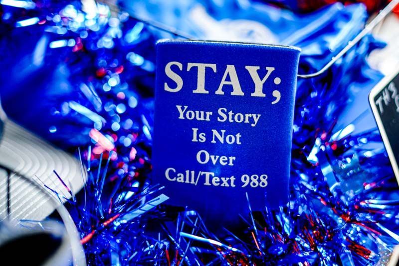 A blue sign that says stay your story is not over call / text 989