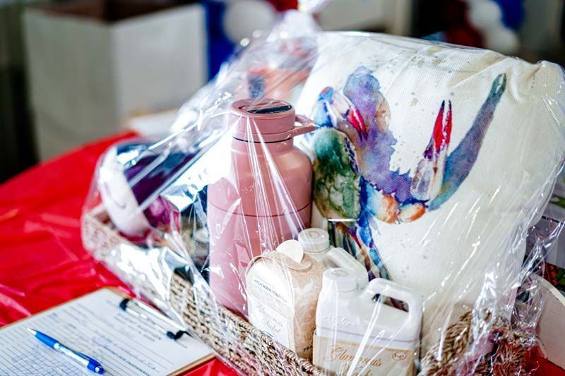 A basket filled with bottles and a pillow is sitting on a table.