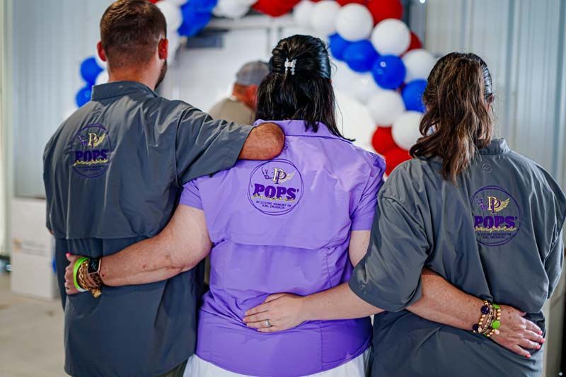 A group of people standing next to each other with their arms around each other.