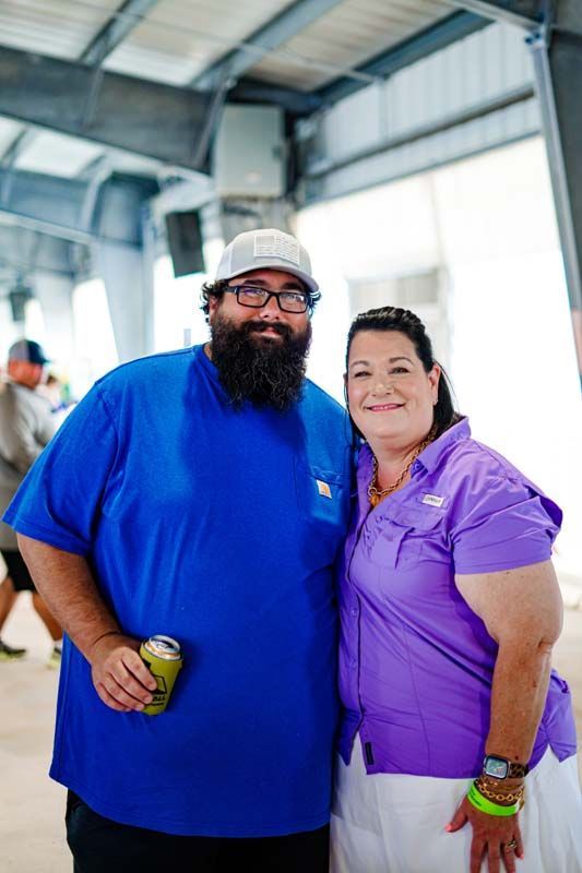 A man with a beard and a woman in a purple shirt are posing for a picture.