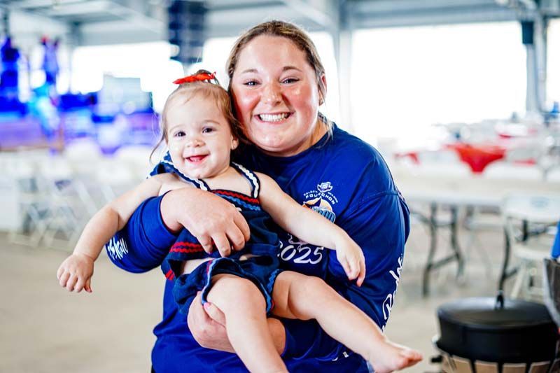 A woman is holding a little girl in her arms.