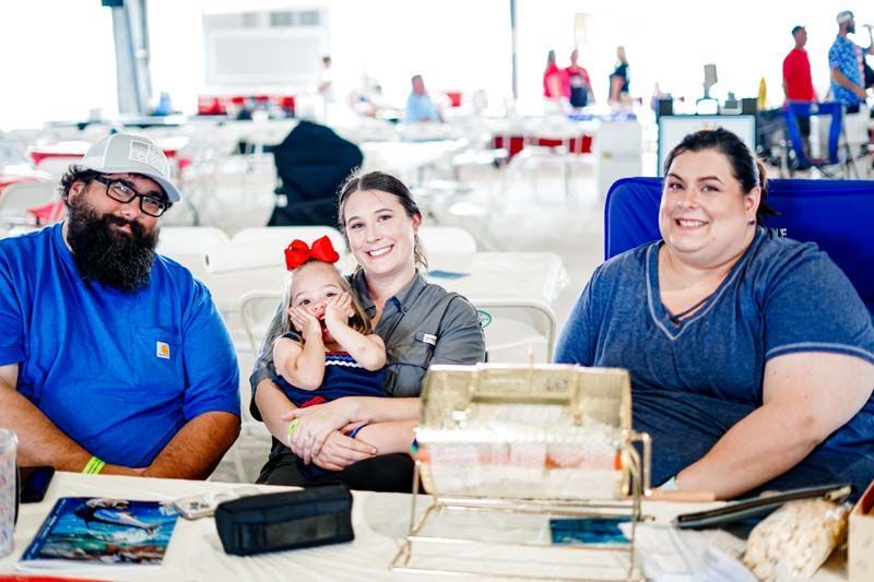 A group of people are sitting at a table with a baby.