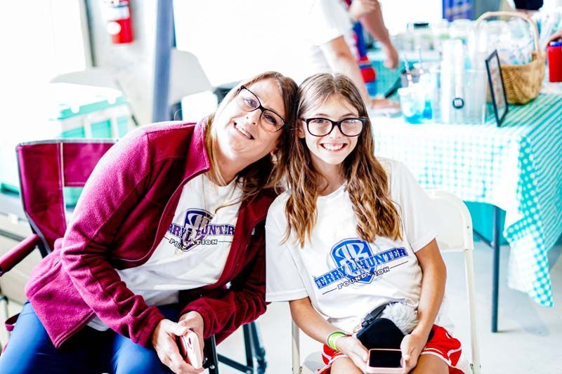 A woman and a girl are sitting next to each other in chairs.
