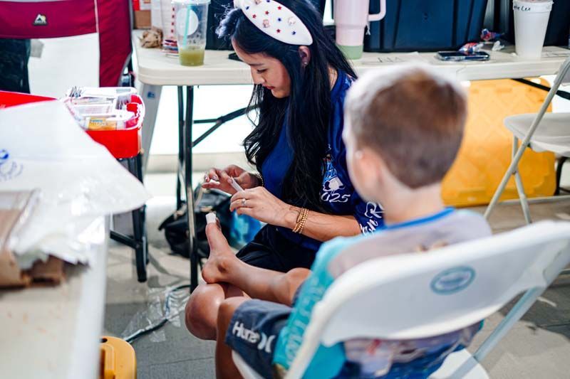 A woman is sitting next to a boy in a chair.