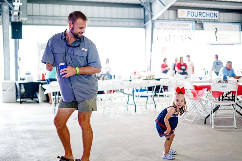 A man and a little girl are dancing in a room.