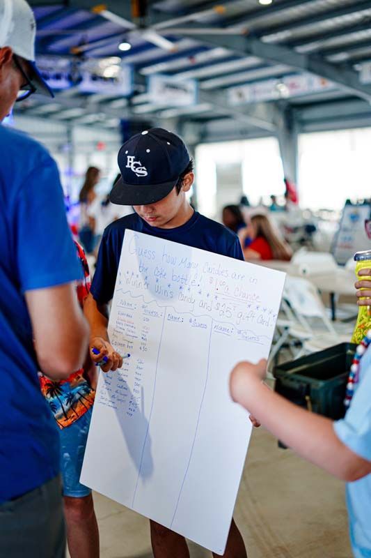 A group of people are standing around a table holding a piece of paper.