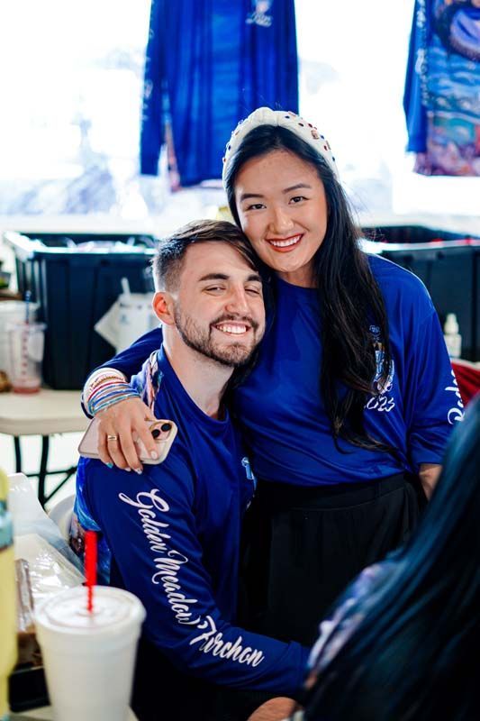 A man and a woman are posing for a picture while sitting at a table.