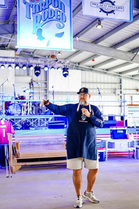 A man is standing in front of a microphone in a warehouse.