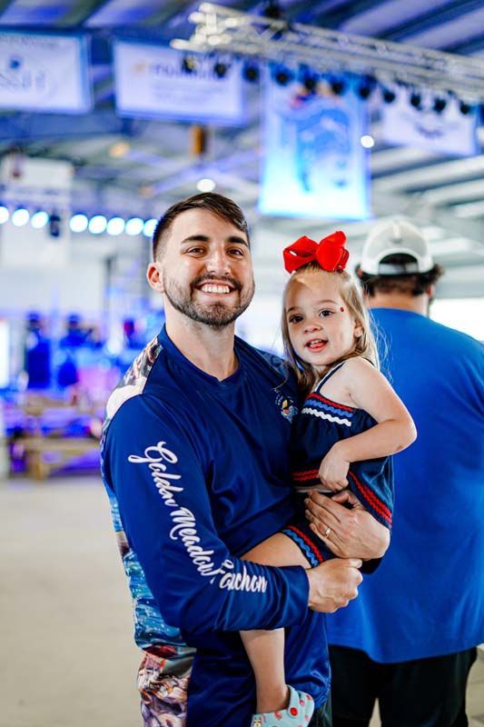 A man is holding a little girl in his arms.