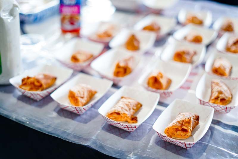 A bunch of food in paper containers on a table.