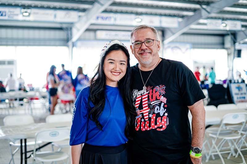 A man and a woman are posing for a picture in a restaurant.