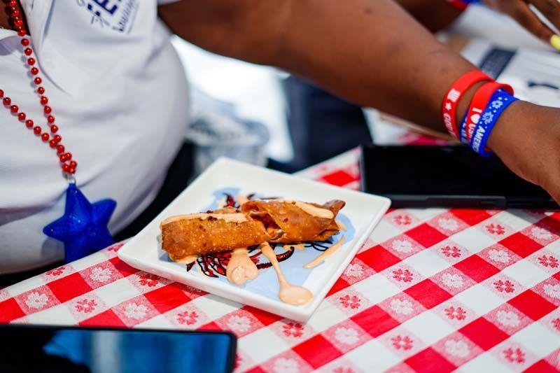 A person is sitting at a table with a plate of food on it.