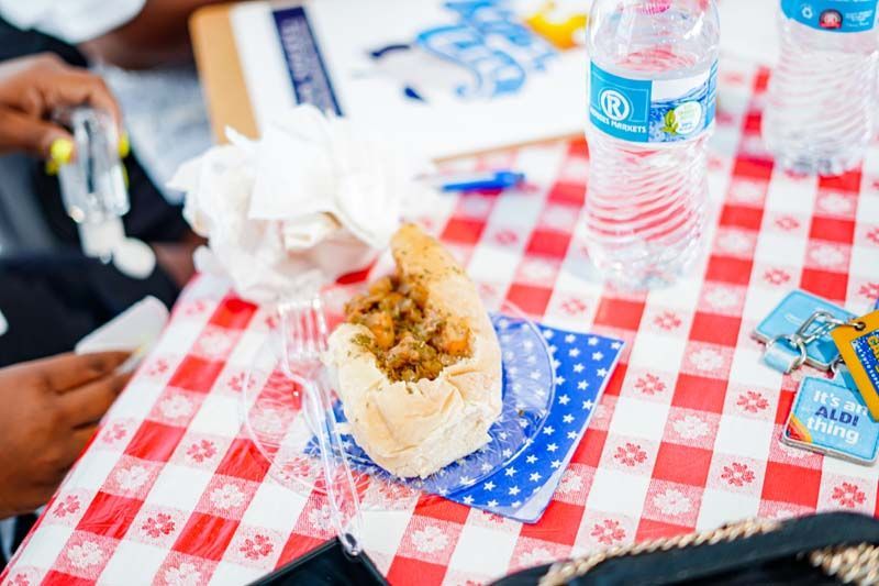 A person is sitting at a table with a plate of food and a bottle of water.