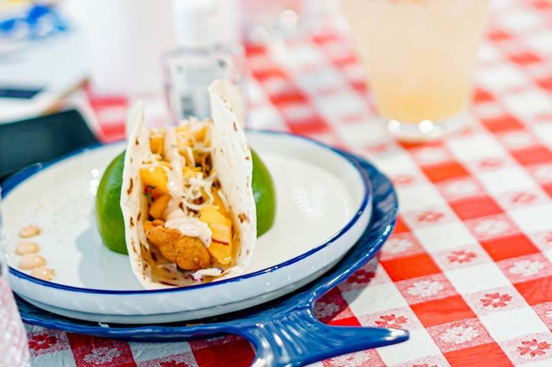 A close up of a taco on a plate on a table.