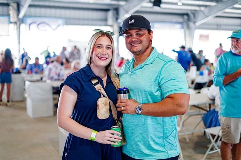 A man and a woman are posing for a picture at a party.