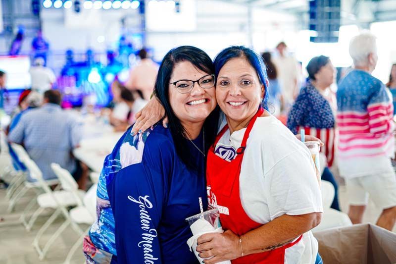 Two women are posing for a picture together at a party.