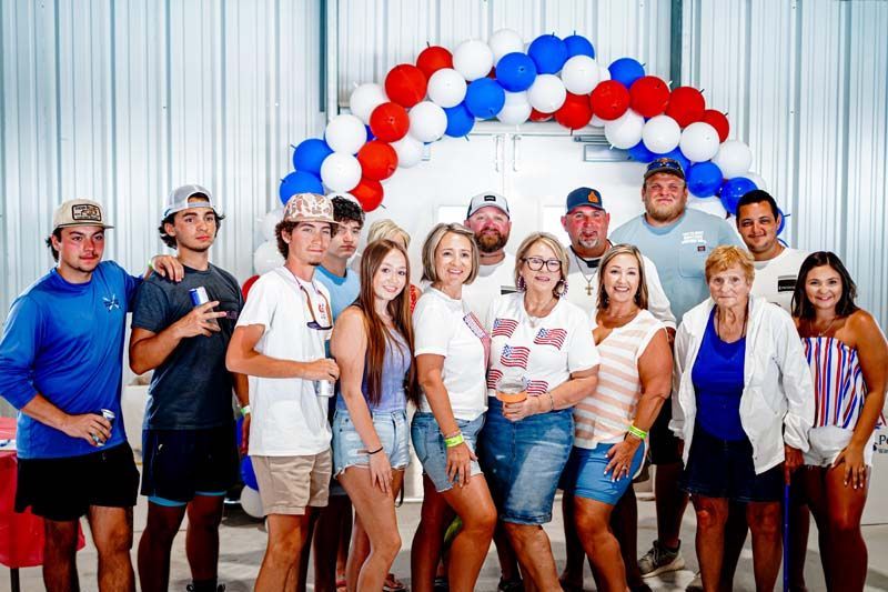 A group of people are posing for a picture in front of balloons.