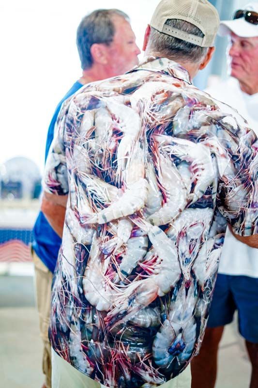 A man wearing a shirt with shrimp on it