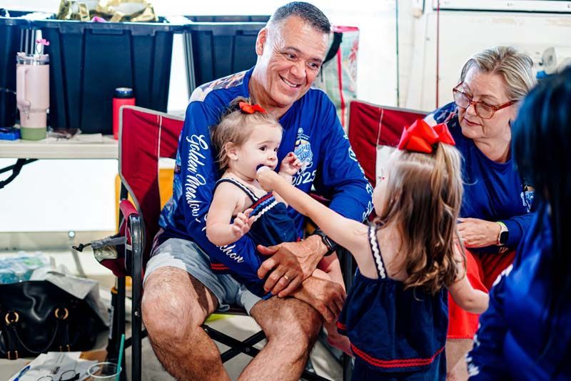 A man is sitting in a chair with two little girls.