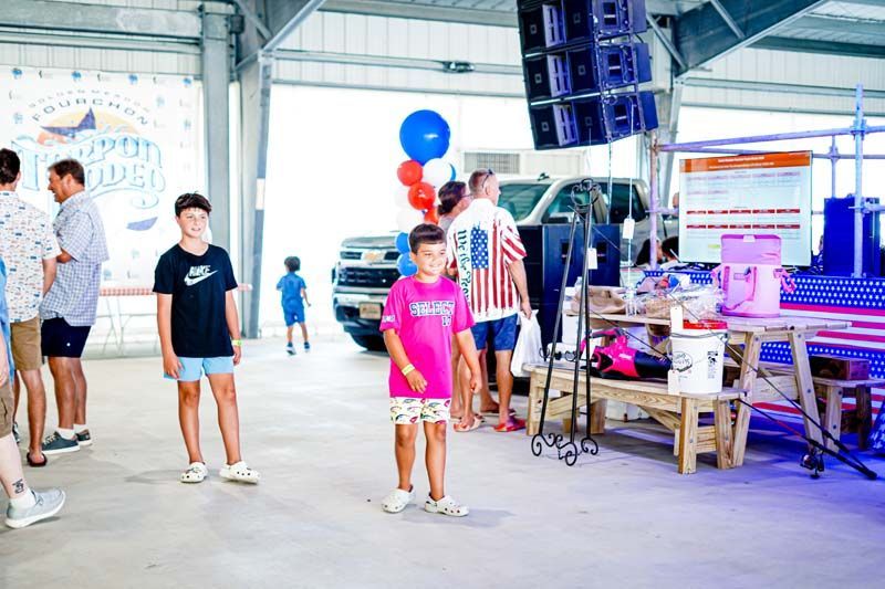 A group of people are standing in a room in front of a truck.