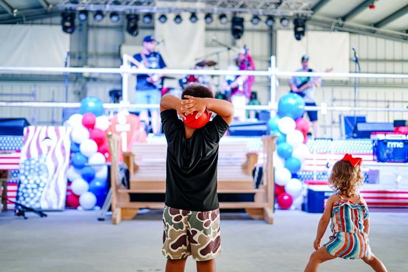 A boy and a girl are playing with balloons on a stage.