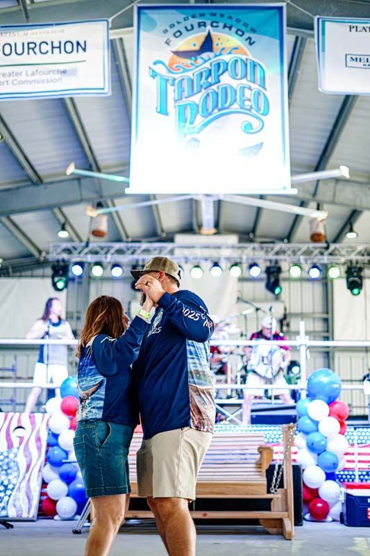 A man and a woman are dancing on a stage in front of a sign that says toppon rodeo.