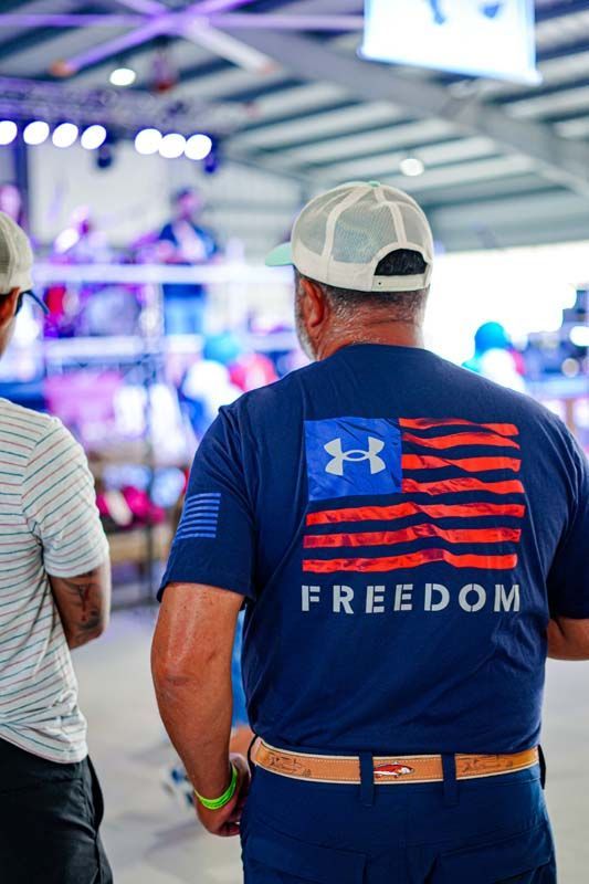 A man wearing a blue under armour t-shirt with an american flag on it.