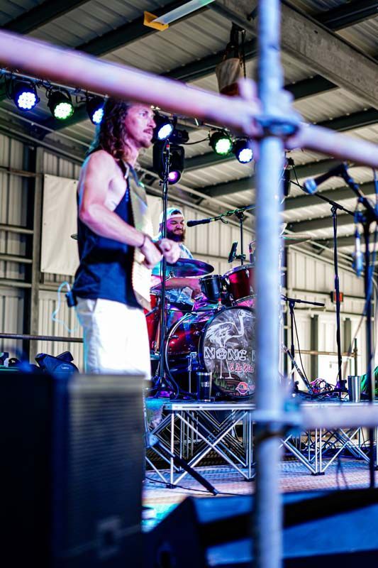 A man is playing a guitar on a stage in front of a microphone.