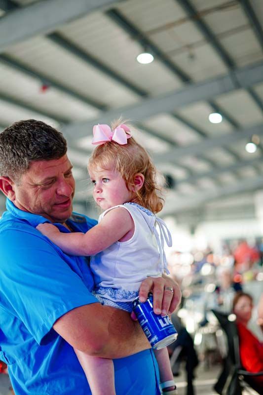 A man is holding a little girl in his arms.
