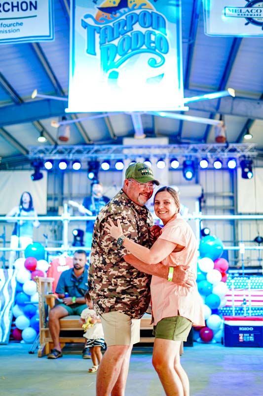 A man and a woman are dancing in a room with balloons.