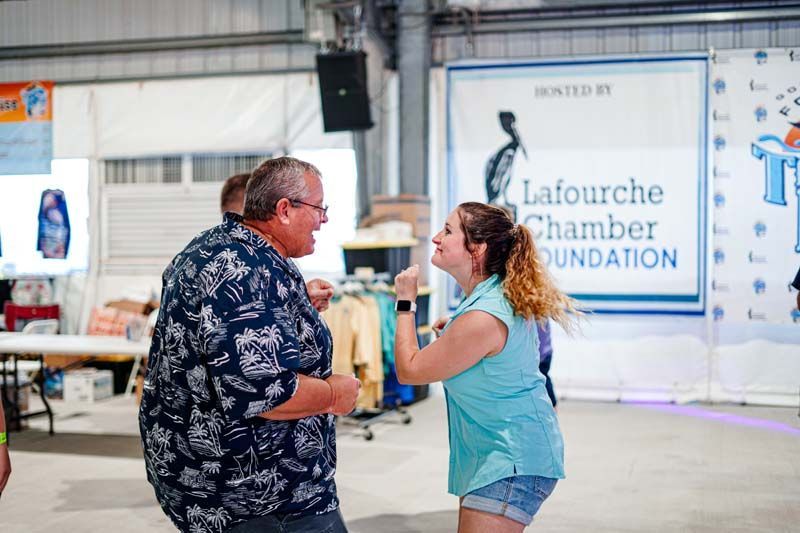 A man and a woman are dancing together in a room.