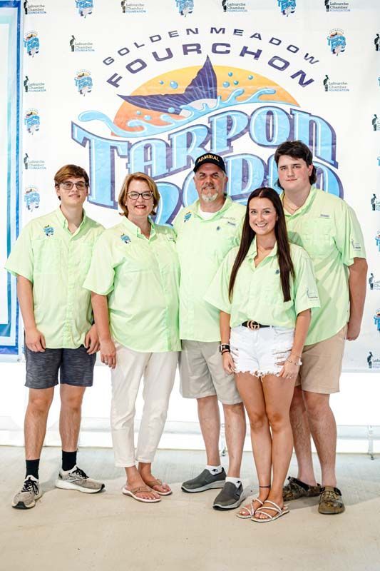 A group of people are posing for a picture in front of a sign.