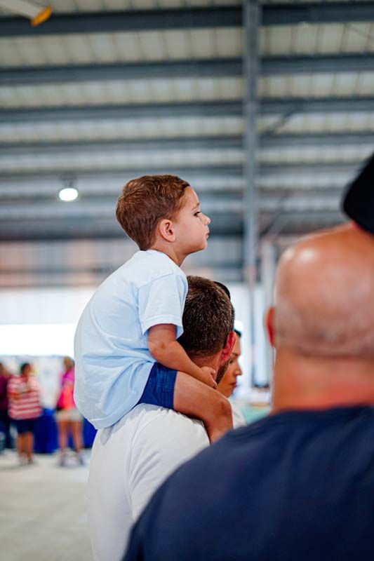 A man is carrying a little boy on his shoulders.