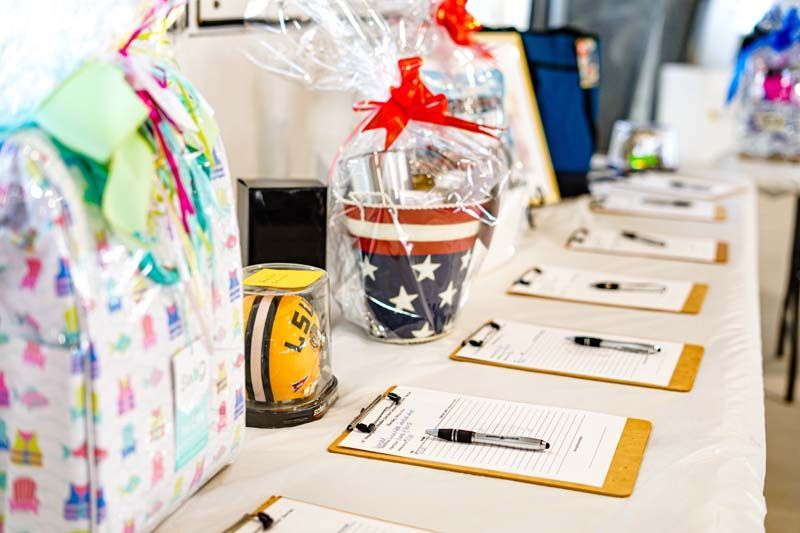 A table with a row of clipboards and a basket on it.