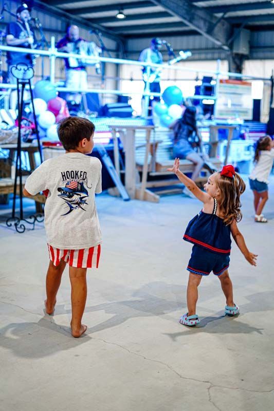 A boy and a girl are dancing in a warehouse.