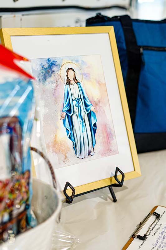 A painting of mary is sitting on a table next to a clipboard.
