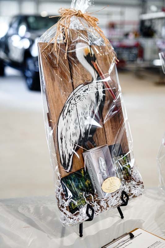 A painting of a pelican is wrapped in plastic and sitting on a table.