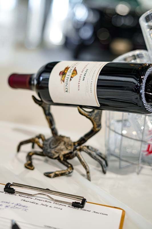 A bottle of wine is sitting on top of a crab shaped wine holder.