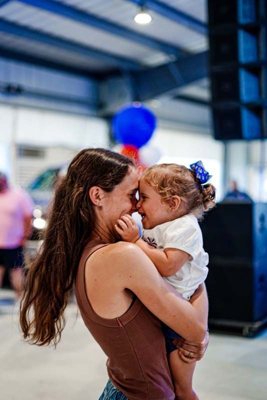 A woman is holding a little girl in her arms.