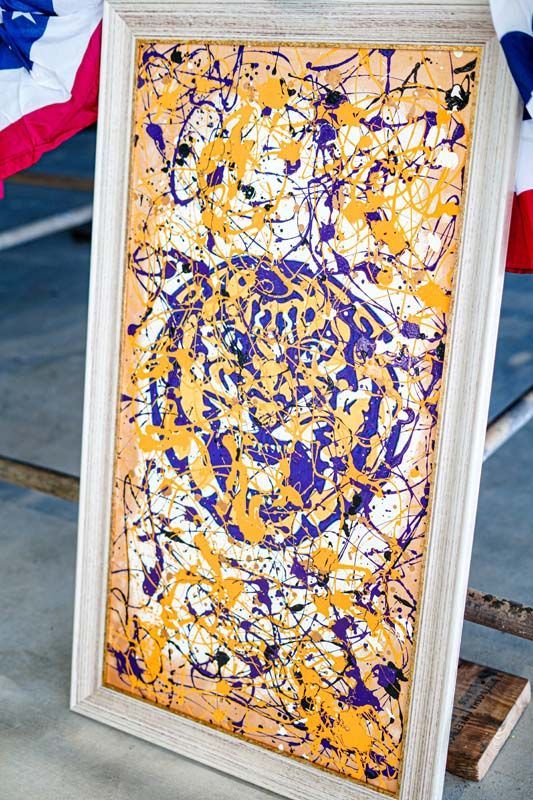 A framed painting of a tiger is sitting on a table.