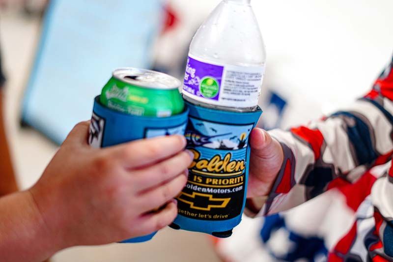 A person is holding a can of soda and a bottle of water.