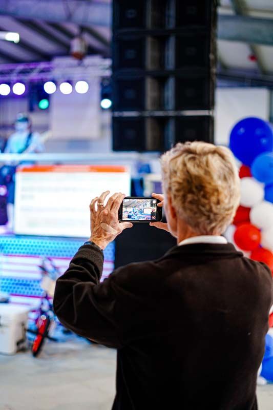 A man is taking a picture with a cell phone at a party.