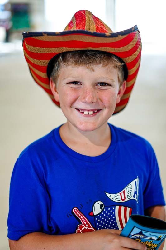 A young boy wearing a cowboy hat and a blue shirt