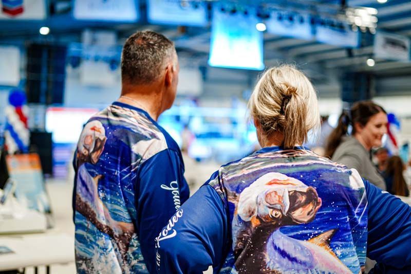 A man and a woman are standing next to each other wearing shirts with dolphins on them.