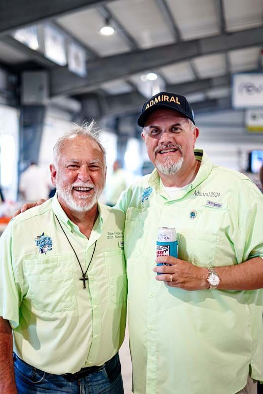 Two men are posing for a picture together in a building.