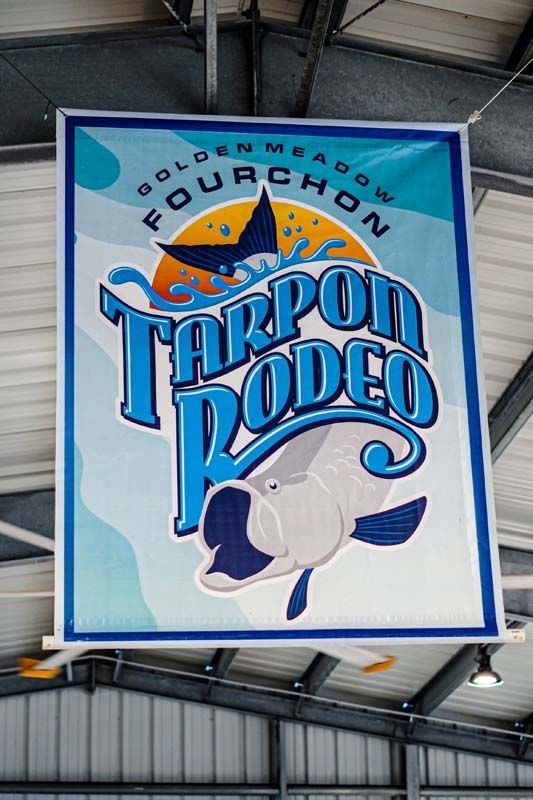 A tarpon rodeo sign is hanging from the ceiling of a building.